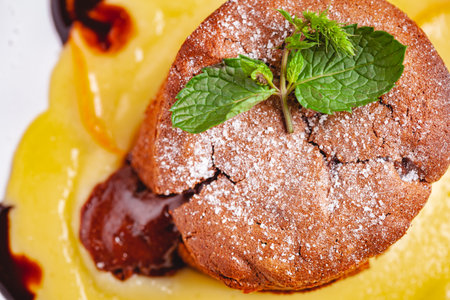 Chocolate fondant served with custard cream on white plate. Lava cake recipe. Top view. Close upの写真素材