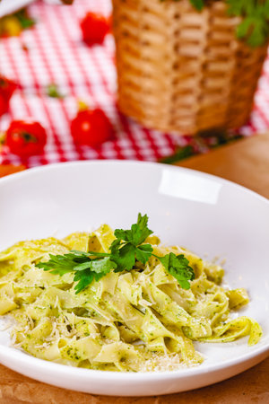 Italian Pasta tagliatelle with pesto sauce and parmesan cheese on white plate. Close upの写真素材