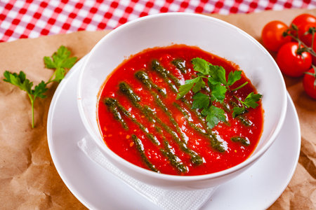 Tomato cold gazpacho soup with pesto sauce in white bowl. Close upの写真素材