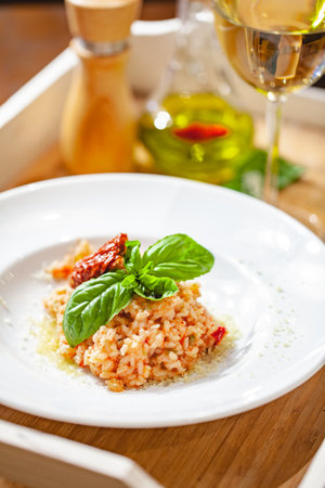 Risotto with sun-dried tomatoes and capers on white plate. Close upの写真素材