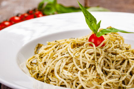Italian pasta spaghetti with homemade pesto sauce on white plate. Close upの写真素材