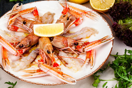 Seafood. Langoustine, scampi or Norway lobster with lemon on white plate.の写真素材