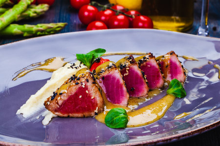 Grilled Tuna steak in sesame seeds and fennel puree on a plate.の写真素材