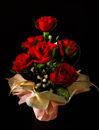 Red rose ,handmade from fabric and shot on black isolated.の写真素材