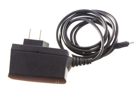 Electric adapter with chord for charging mobile phone,shot on white isolated.