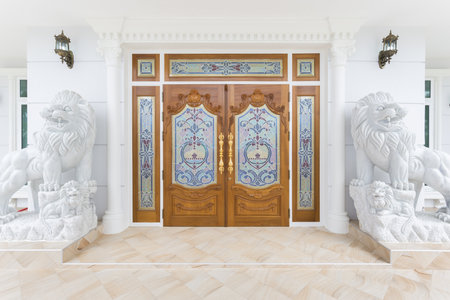 Teak wooden door with white lions statue.の写真素材