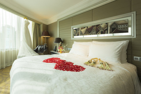 Wedding dress and groom suit in room with rose petals on a bed, wedding decoration, Rose of Bouquet.のeditorial素材