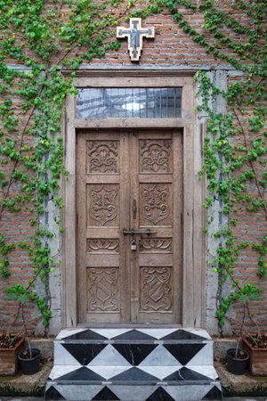 Old wooden church door in the garden.の写真素材