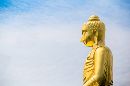 The big Buddha statue against cloudy and blue sky background.の写真素材