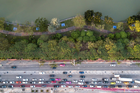 Aerial view of road traffic jam near public park with peoples running exercise inside.のeditorial素材