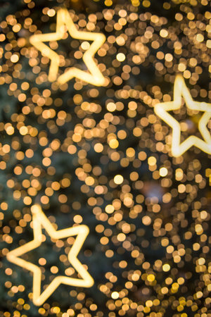 Defocused bokeh and star. Twinkling light warm tone bokeh abstract background for Christmas and Happy new year holiday. Festive elegant blurred background with bokeh circular and bright light.の写真素材