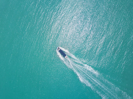 Aerial view of speed boat in sea. Speed boat at sea, view from above. Speedboat floating in a turquoise blue sea water. Motorboat crossing ocean. Tropical landscape. Thailand.の写真素材