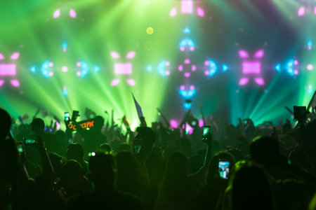 Hand with a smartphone records live music festival Taking photo of concert stage live concert music festival happy youth luxury party landscape exterior.の写真素材