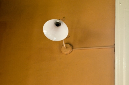 white wall lamp without bulb on a brown wallの写真素材