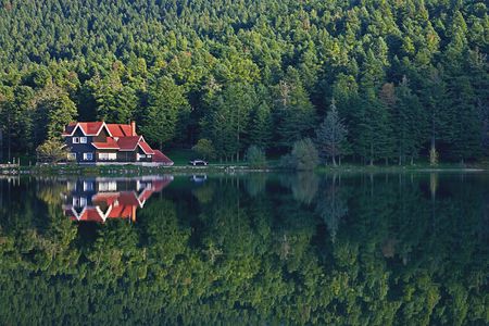 house at the forest lake with reflectionの写真素材