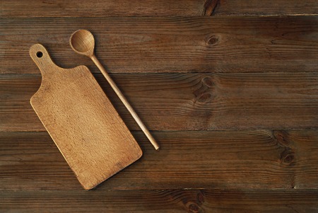 top view of wooden cutting board with spoon on old wooden tableの写真素材