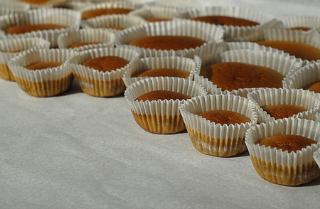 Different sizes homemade baked cupcakes on the backing paperの写真素材