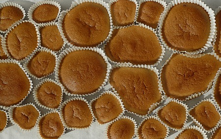 Different sizes homemade baked cupcakes on the backing paperの写真素材