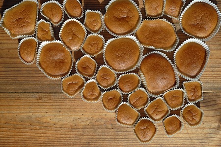 Different sizes homemade baked cupcakes on the wooden tableの写真素材