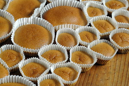 Different sizes homemade baked cupcakes on the wooden tableの写真素材