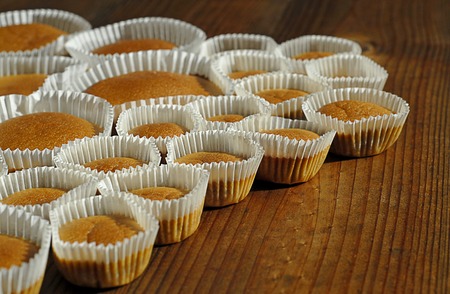 Different sizes homemade baked cupcakes on the wooden tableの写真素材