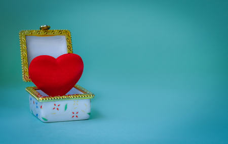 Jewelry box with a red heart inside on blue backgroundの写真素材