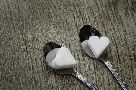 White sugar hearts with two tea spoonsの写真素材