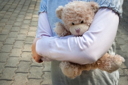 Lonely girl holding a teddy bear as her best friendの写真素材
