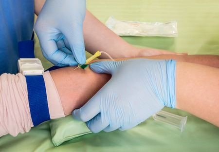 Nurse taking blood sample from vein of a child