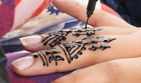 Henna tattoos being put on girls hand in Moroccoの写真素材