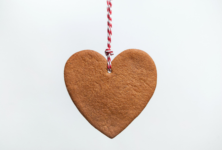 Heart shaped christmas gingerbread cookie on white backgroundの写真素材