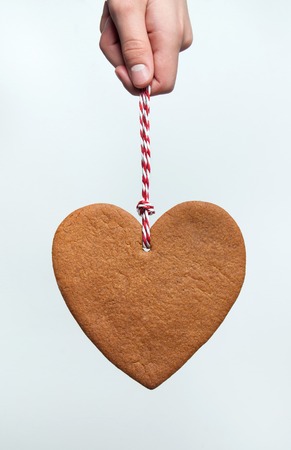 Heart shaped christmas gingerbread cookie on white backgroundの写真素材