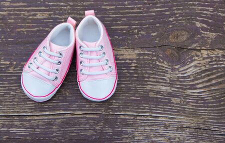 Baby girl pink shoes on wooden backgroundの写真素材