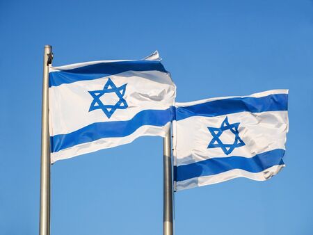 Two national flags of Israel outdoors against the blue sky