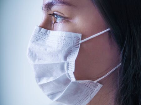 Pandemic Coronavirus. Close up of young woman with surgical mask on face against virus.