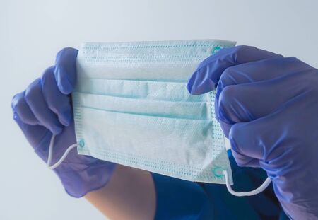 Nurse holding protection face mask against coronavirusの写真素材