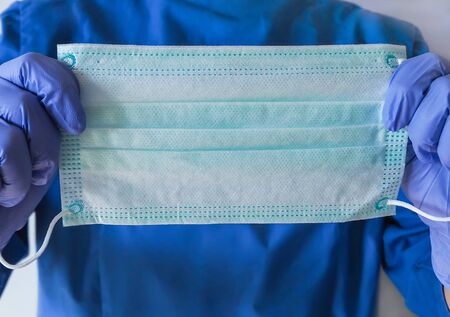 Nurse holding protection face mask against coronavirus