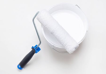 Painting equipment, roller with a bucket of white paint on white backgroundの写真素材