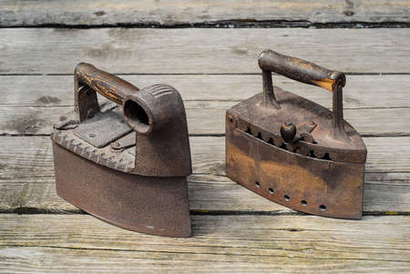 Old antique irons on vintage wooden background
