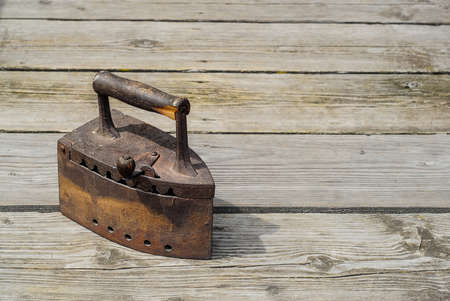 Old antique irons on vintage wooden backgroundの写真素材