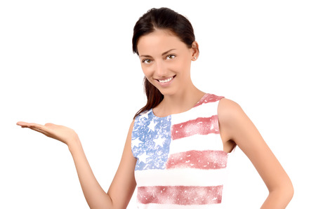 Beautiful American girl presenting. Attractive girl with USA flag on her blouse. Isolated on white.の写真素材