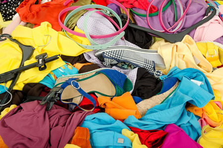 Close up on a big pile of clothes and accessories thrown on the ground.  Untidy cluttered wardrobe...