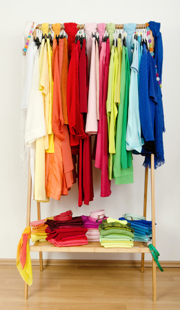 Wardrobe with summer clothes nicely arranged  Dressing closet with color coordinated clothes on hangers and shelf の写真素材