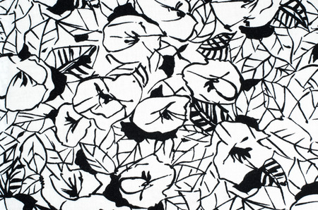 Graphic floral pattern on fabric. Black and white flowers print as background.