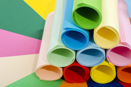Roles of color paper. Color paper rolled and piled. Stack of paper on multicolor background.