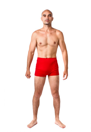 Full body of fit muscular man wearing only red underwear. Topless guy isolated on white.の写真素材