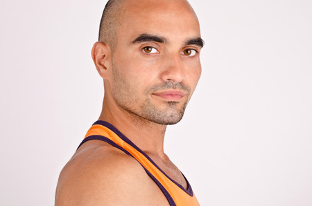 Portrait of a man. Profile of a handsome bald man. Fit athletic man in orange tank top.の写真素材
