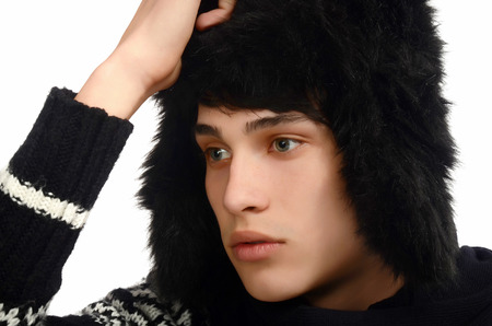 Portrait of a handsome man dressed for a cold winter. Man wearing a sweater and hat. Isolated on...