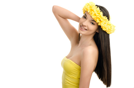 Portrait of a sexy woman with wreath of yellow flowers on the head. Beautiful smiling brunette woman wearing a ringlet of flowers. Girl with long straight hair.の写真素材