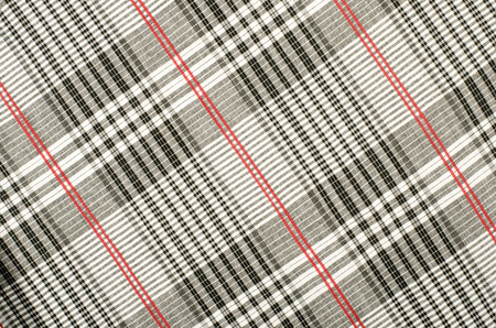 Scottish tartan pattern. Red with white and black plaid print as background. Symmetric rhombus...